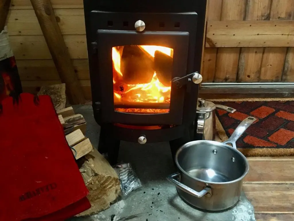 a stove with a pot in front of it at Shepherd's Loch Glamping in Turriff