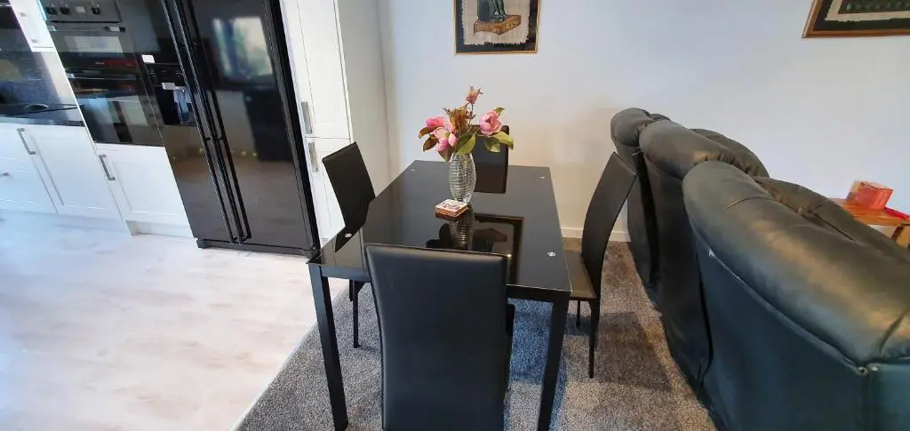 a table with a vase of flowers on top of it at Spacious well equipped Chalet Bungalow close to Nairn, in Auldearn