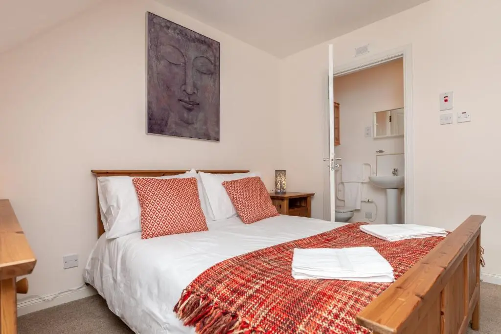 a bedroom with a large bed with red pillows at Historic Village, Rare Find, Amazing Views in Ballater