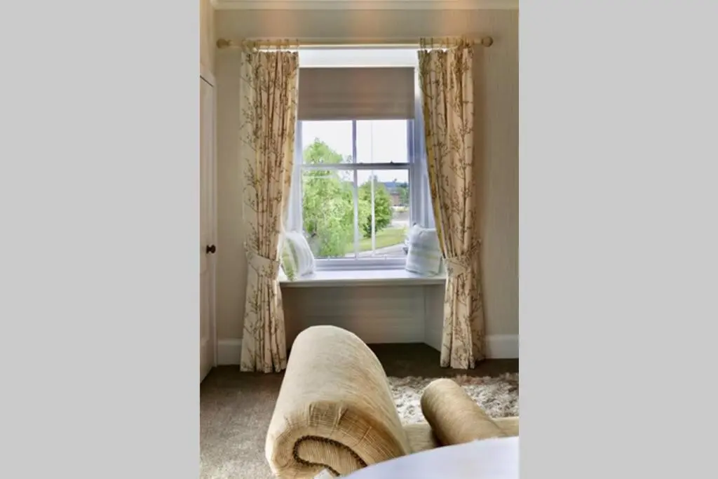 a living room with a window and a couch at St Brendans Apartment in Elgin