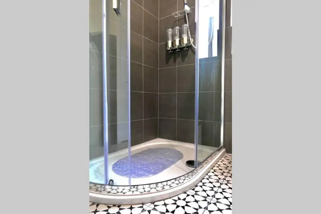 a shower with a glass door in a bathroom at St Brendans Apartment in Elgin