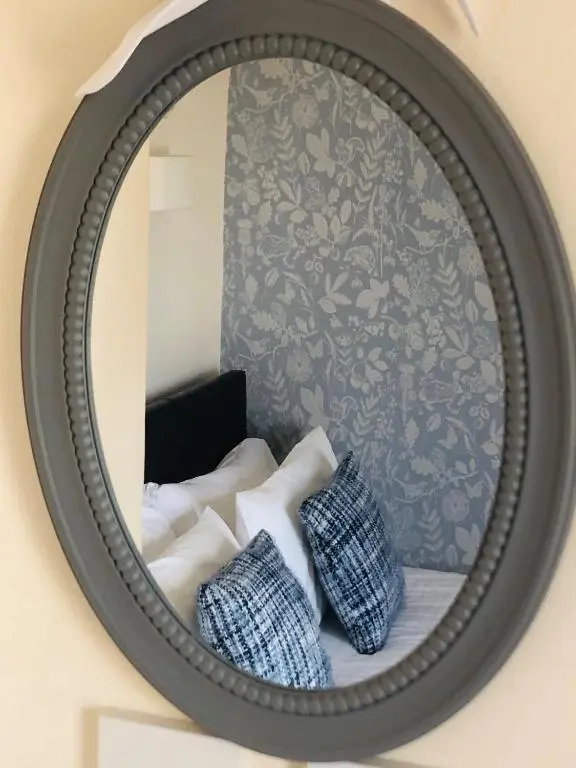 a mirror with two pillows in front of a wall at The Aberdeen Arms Hotel in Tarves