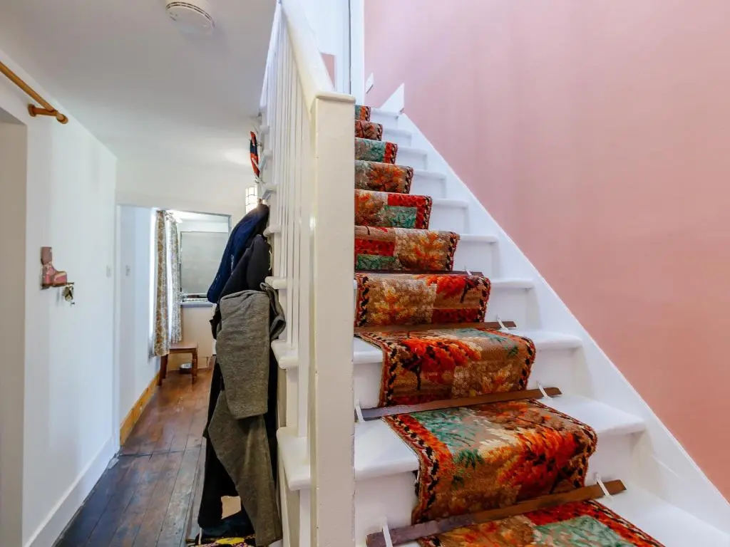 a stairwell with colorful carpeted stairs in a house at 19 South Street in Grantown on Spey