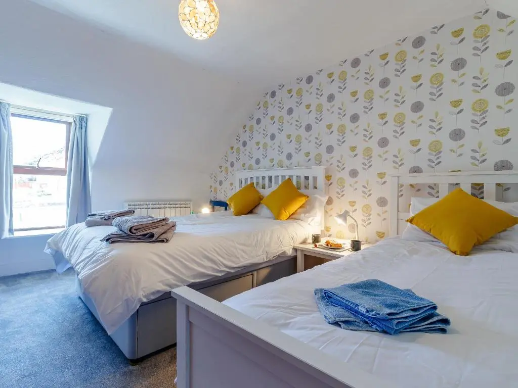 two beds sitting next to each other in a bedroom at 19 South Street in Grantown on Spey