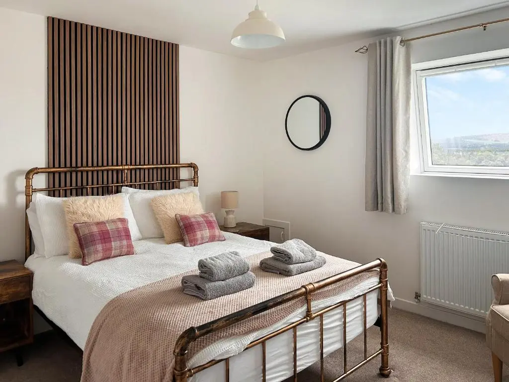 a bedroom with a bed with towels on it at Knocknahighle in Cromdale