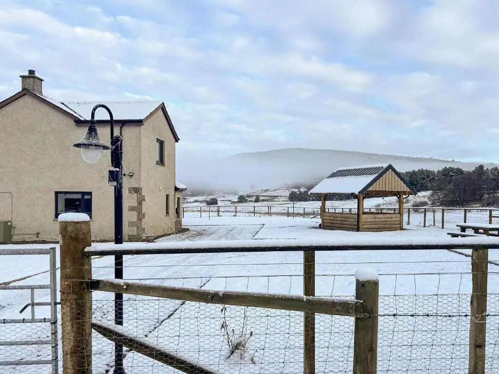 a snowy field with a fence and a gazebo at Knocknahighle in Cromdale