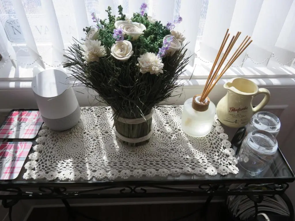 a glass table with a vase with flowers on it at Bankhouse B&B in Aberlour