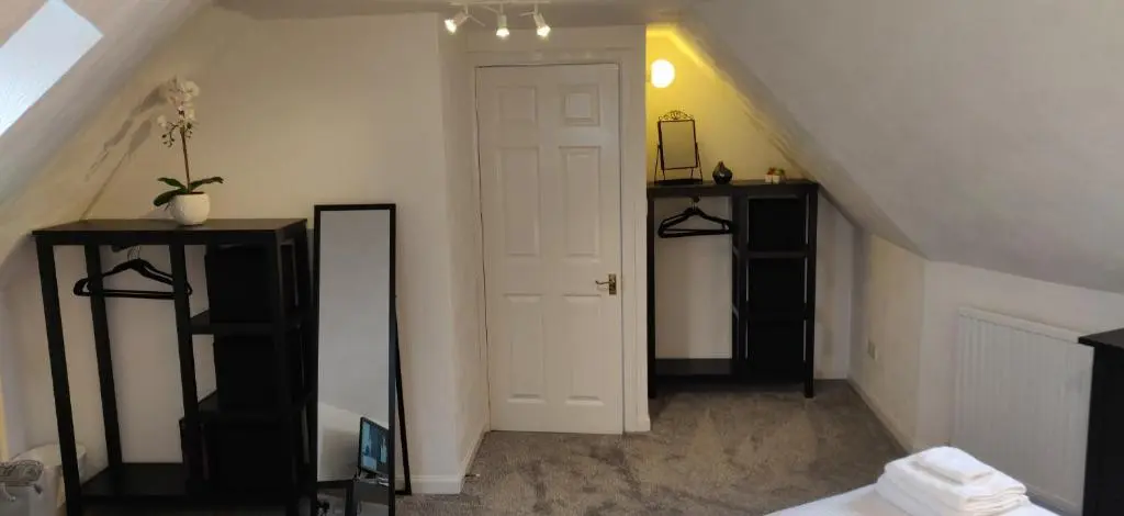 a attic room with a white door and a mirror at 4-Bed Cottage in Portknockie Near Cullen Moray in Portknockie