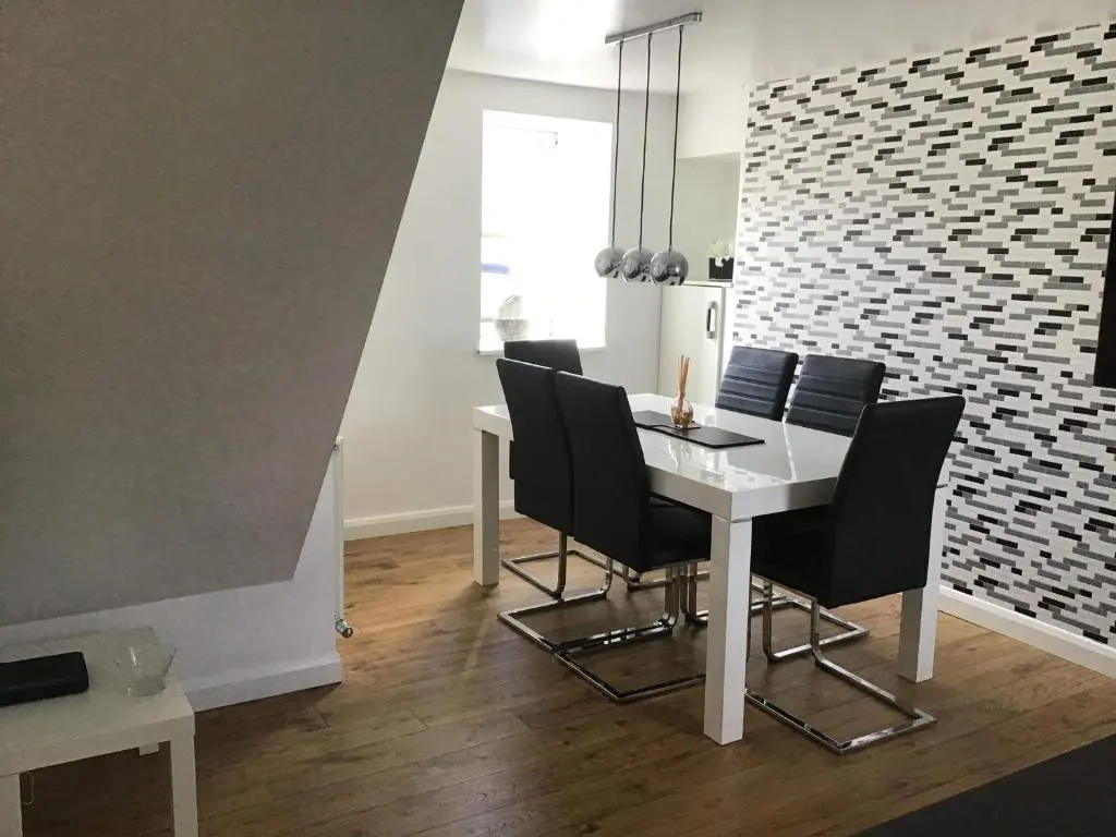 a dining room with a white table and black chairs at 4-Bed Cottage in Portknockie Near Cullen Moray in Portknockie