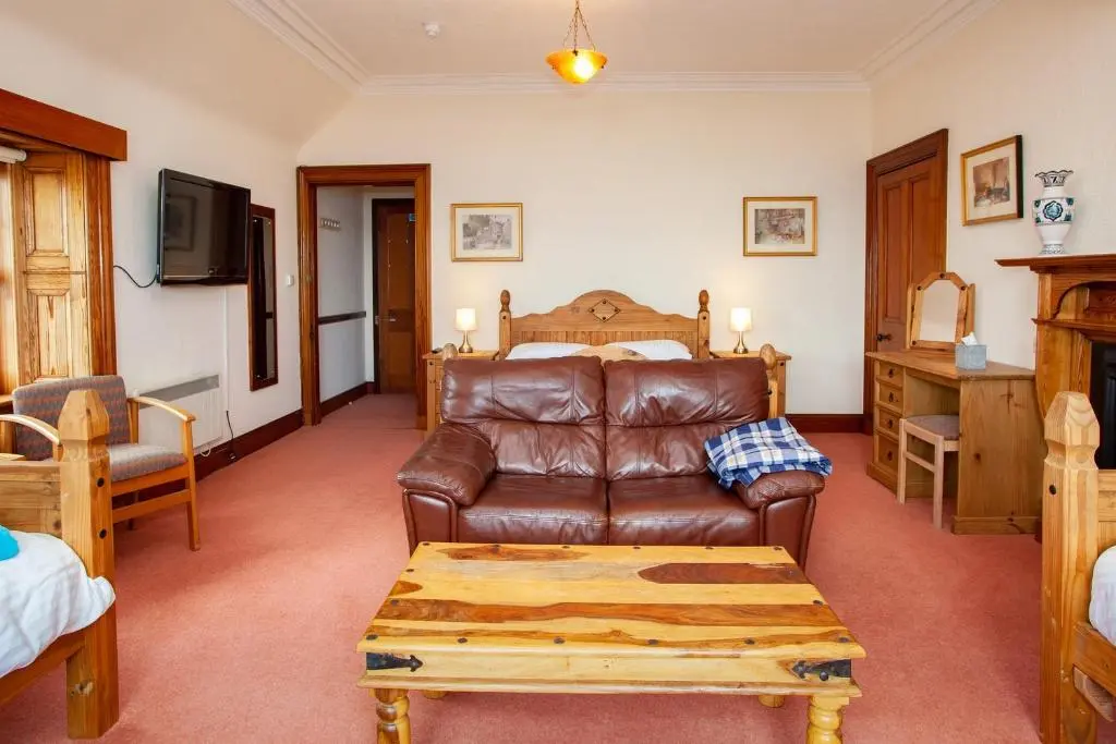 a living room with a couch and a bed at Balintore Inn in Balintore