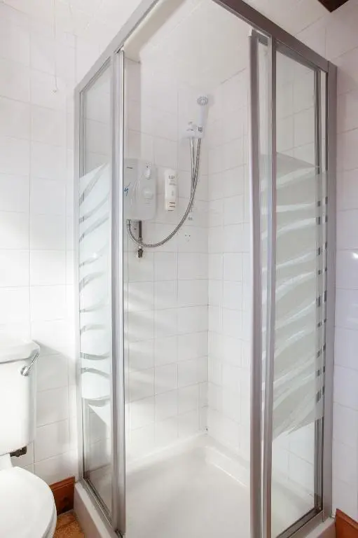 a shower with a glass door in a bathroom at Balintore Inn in Balintore