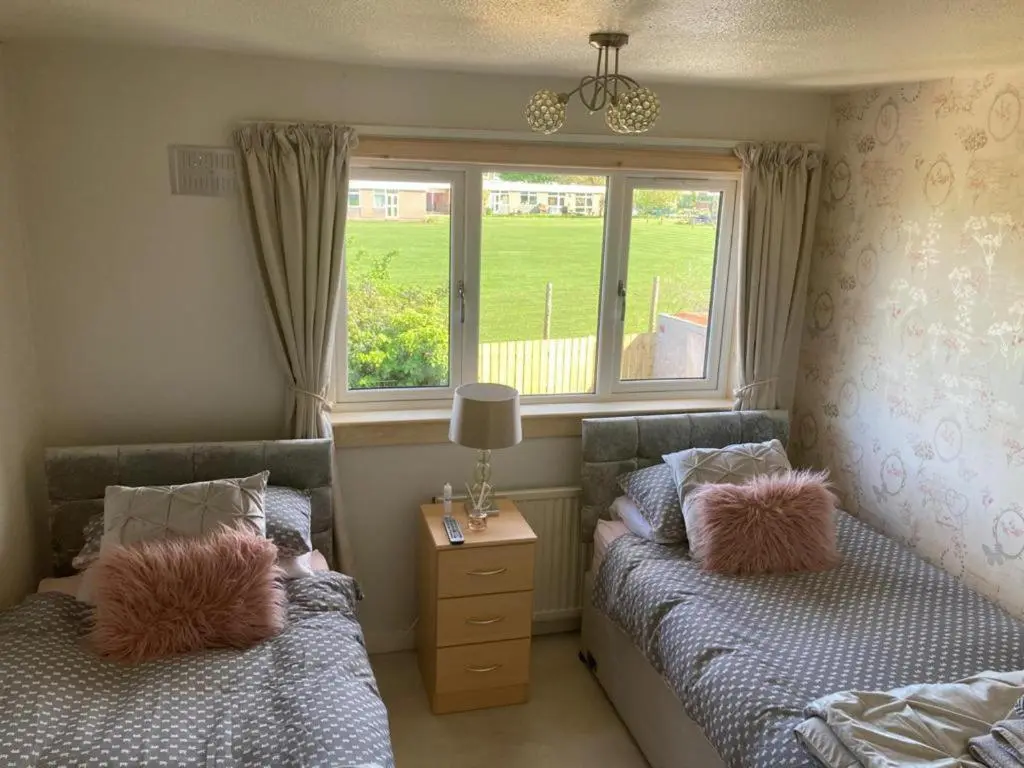 two beds in a small room with a window at 3Bed House - Family Friendly - Close To LochNess in Inverness