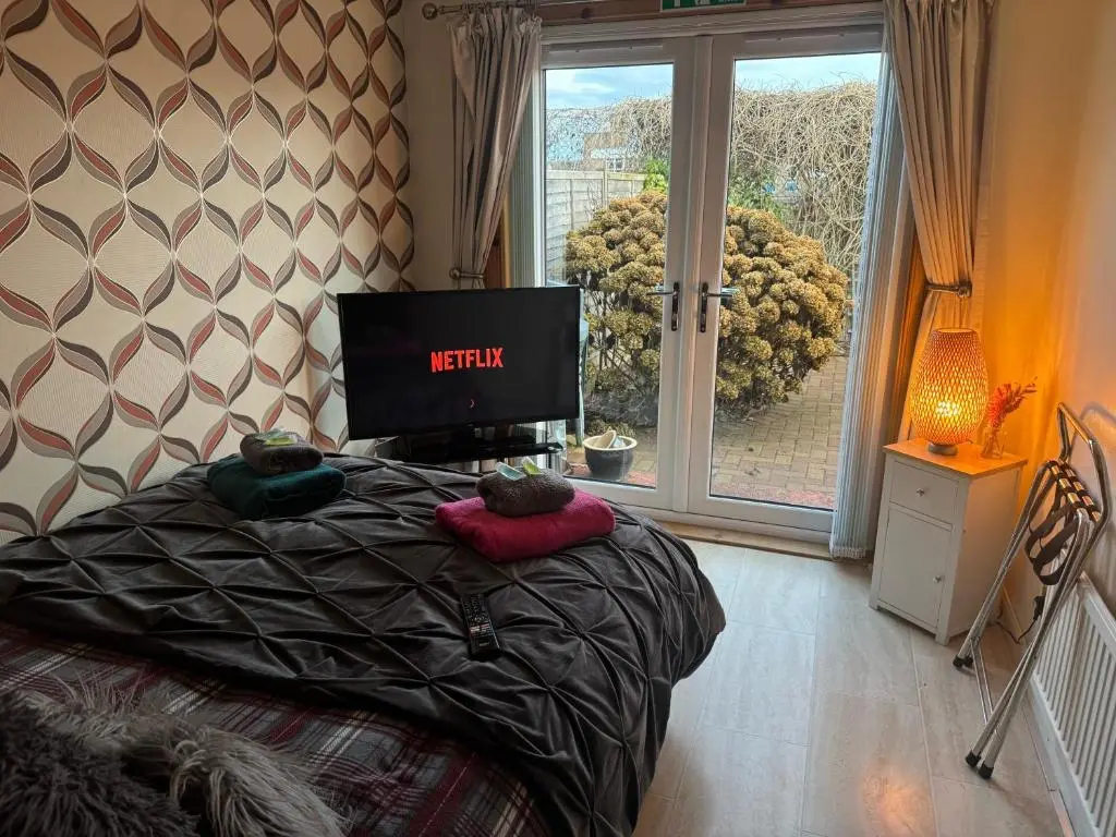 a bedroom with a bed with a television and a window at 3Bed House - Family Friendly - Close To LochNess in Inverness