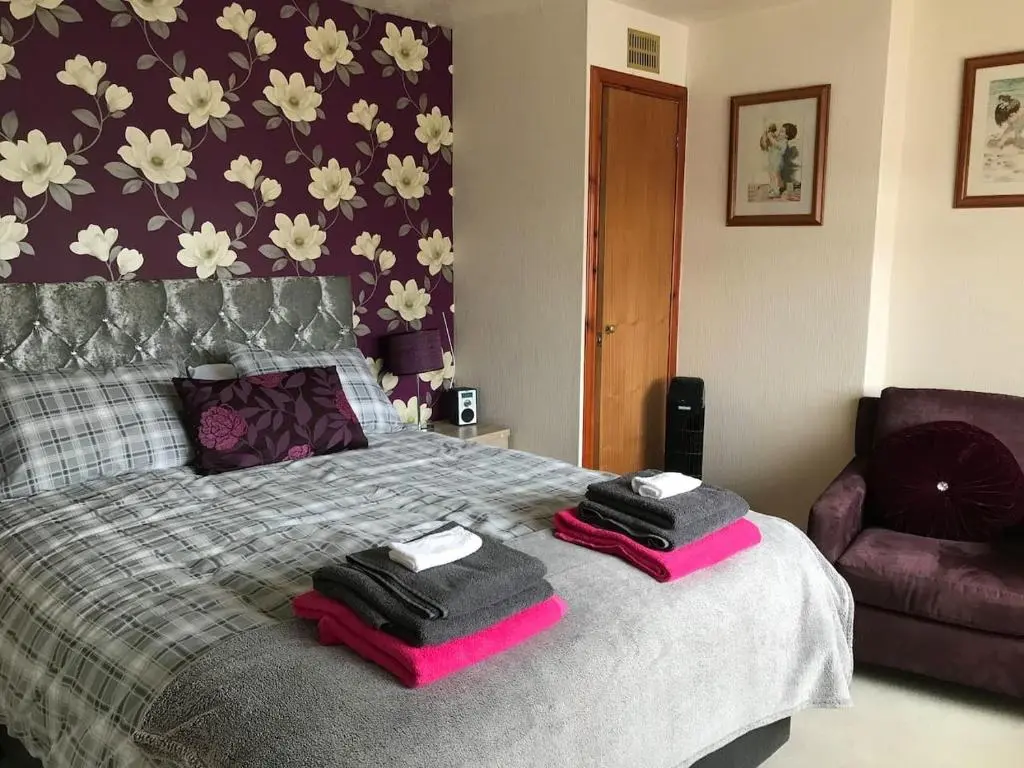 a bedroom with a bed with two towels on it at 3Bed House - Family Friendly - Close To LochNess in Inverness