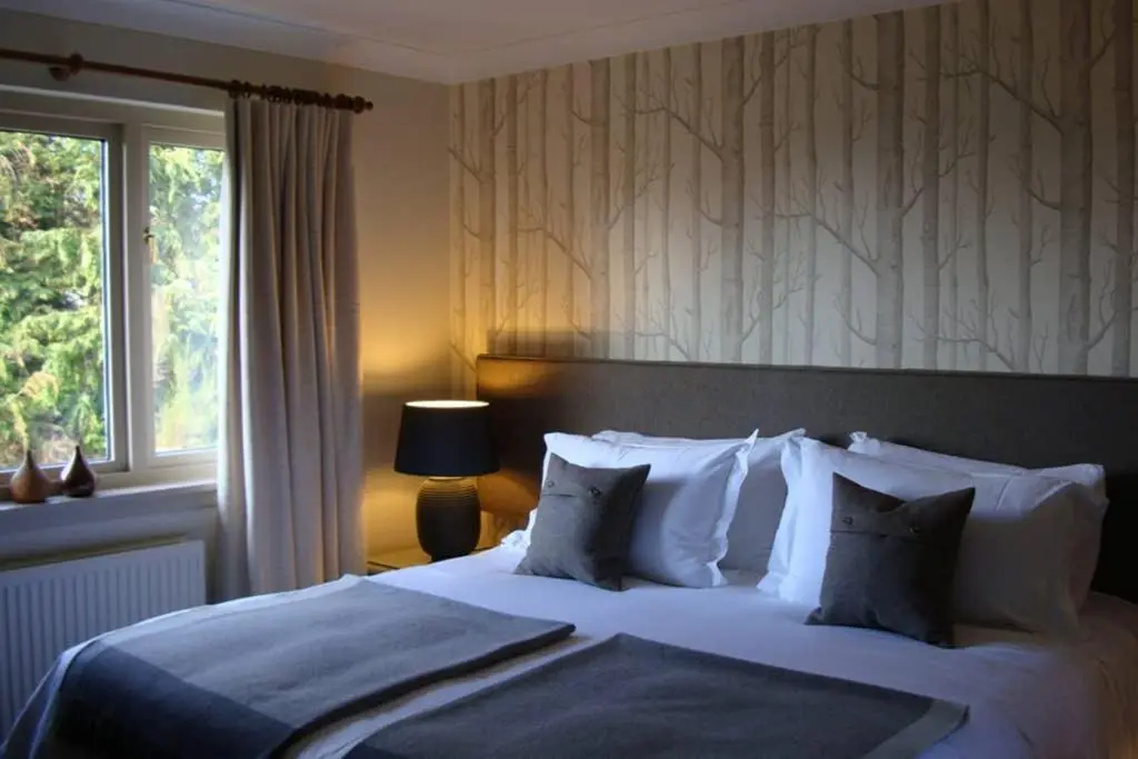 a bedroom with a large bed with pillows and a window at Highfield House in Dornoch
