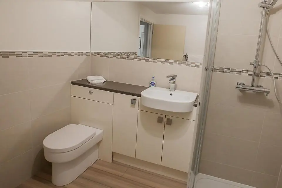 a bathroom with a toilet and a sink and a shower at 2 Bed Blackburn Village Apt With Wifi & Parking in Aberdeen