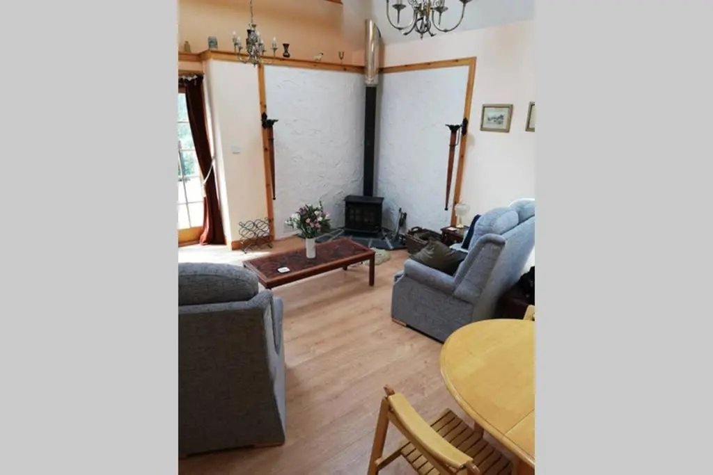 a living room with two couches and a table at Boghead Cottage: Holiday Cottage in Royal Deeside in Banchory