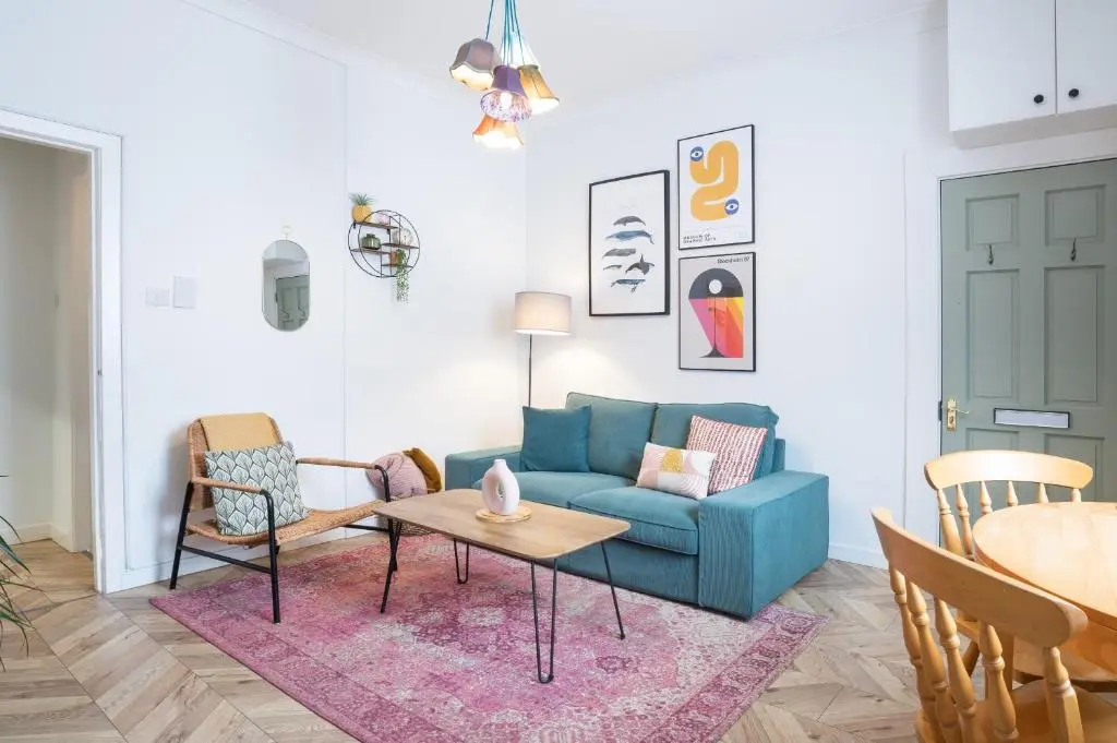 a living room with a blue couch and a table at Macdonald Street Snug in Inverness