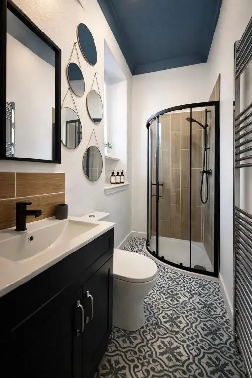 a bathroom with a shower and a toilet and a sink at Macdonald Street Snug in Inverness