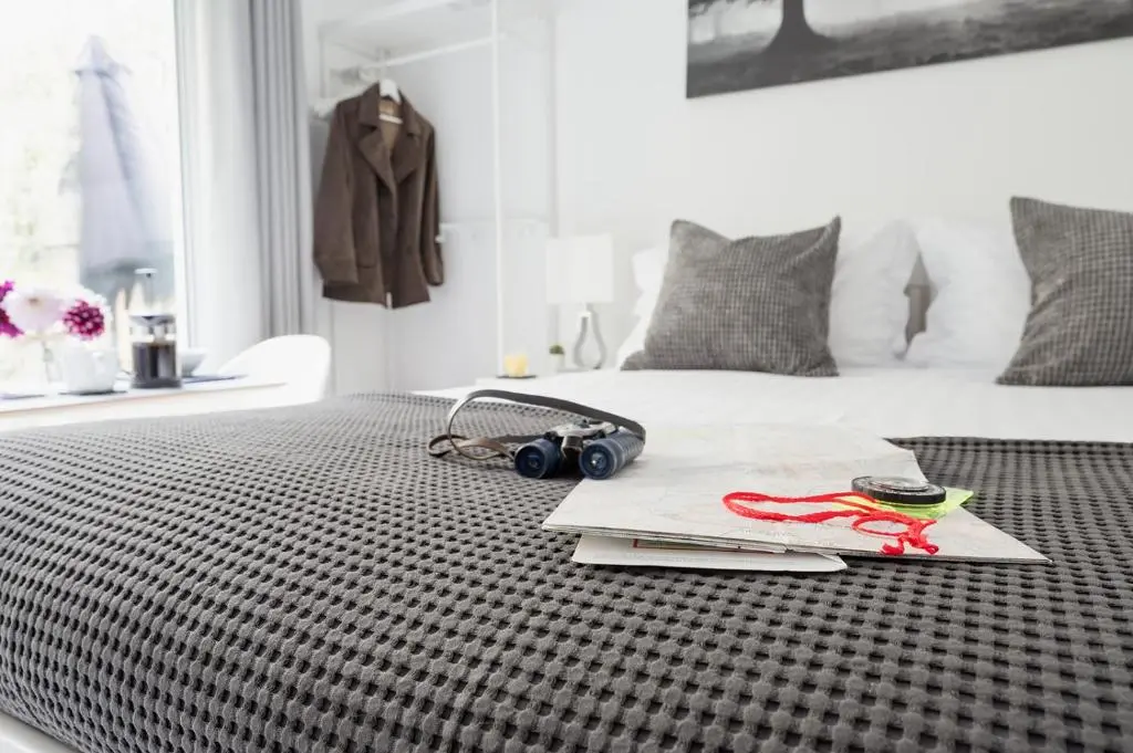 a bedroom with a bed with a black and white bedspread at Siskin Guest Suite in Kinrara