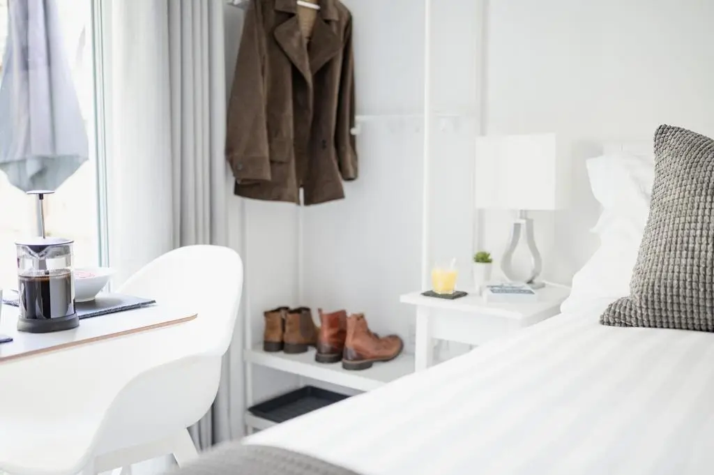 a bedroom with a white bed and a coat hanging on a wall at Siskin Guest Suite in Kinrara