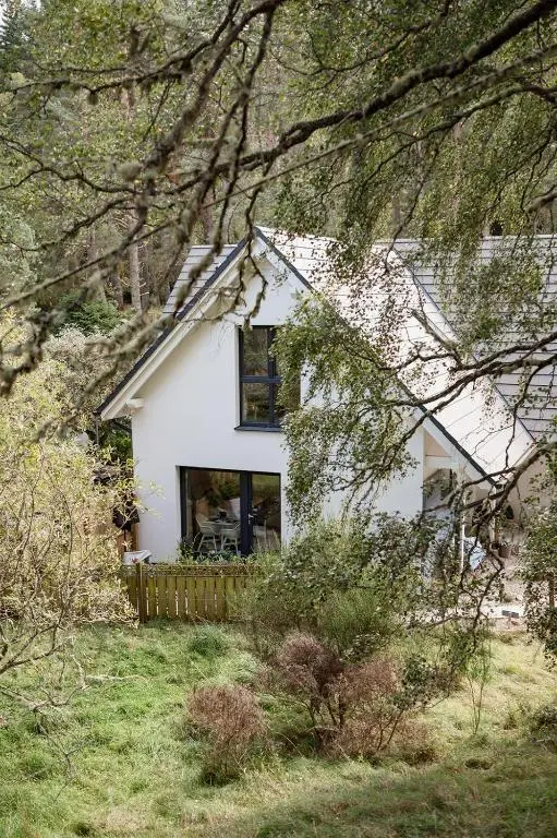 a white house with a window in a yard at Siskin Guest Suite in Kinrara