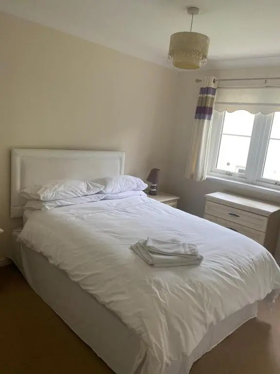 a bedroom with a white bed with two towels on it at Kingseat 3 Bed Home With Fast Fibre WiFi &Parking in Newmachar