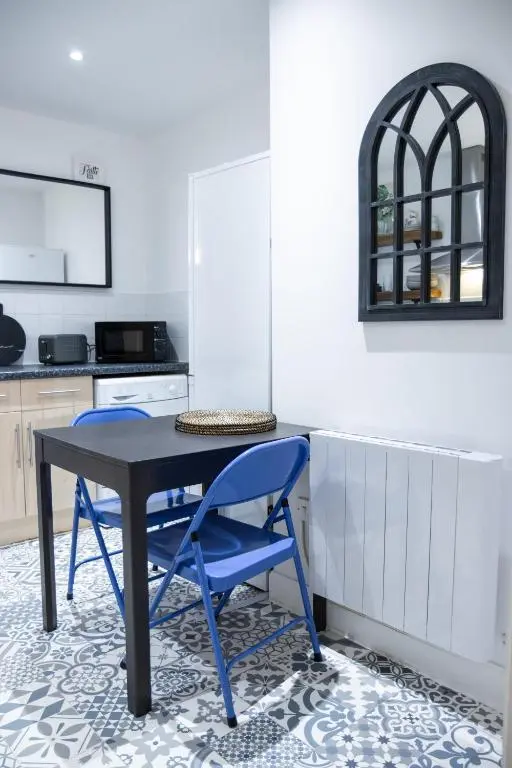 a kitchen with a table and two blue chairs at Ness Central in Inverness