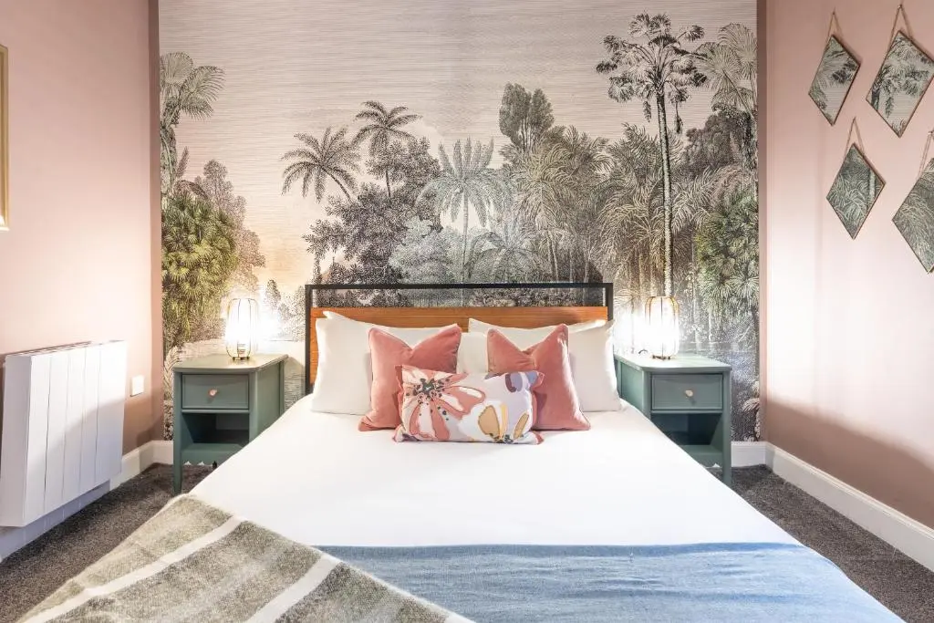 a bedroom with a white bed with pink pillows at Ness Central in Inverness