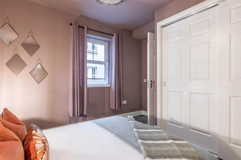 a bedroom with a white door and a window at Ness Central in Inverness