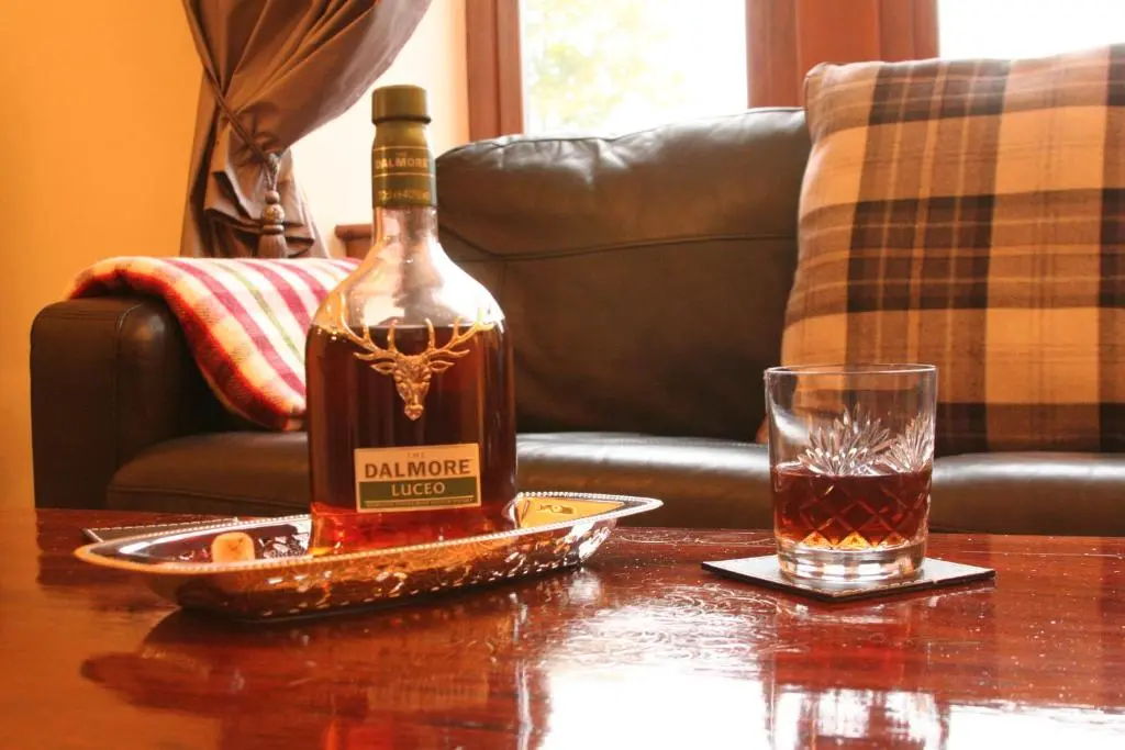 a bottle of whiskey sitting on a table next to a glass at Glenfiddich in Nairn
