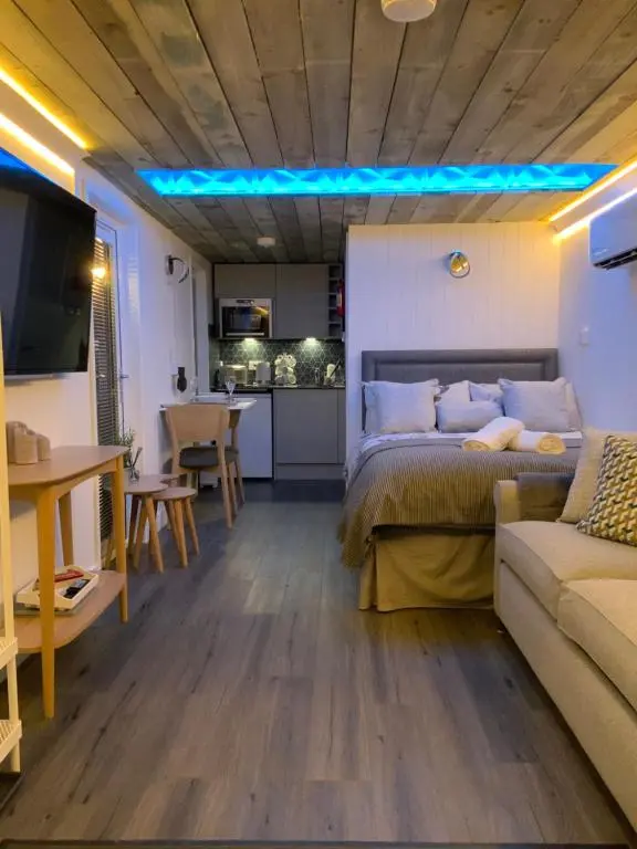 a room with a bed and a couch and a kitchen at Royal Snug & Wee Snug Cabins in Kincardine O\u02bcNeil