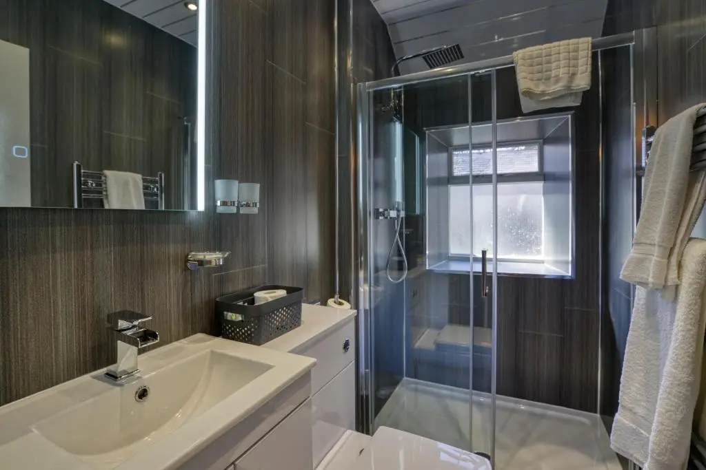 a bathroom with a sink and a glass shower at Golspie Inn in Backies