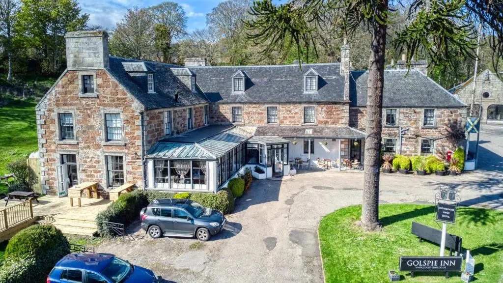 an aerial view of a large brick house with a car parked in front at Golspie Inn in Backies