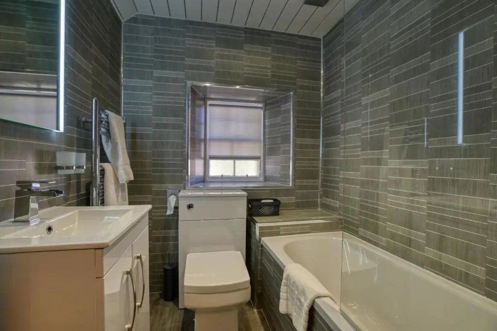 a bathroom with a tub and a toilet and a sink at Golspie Inn in Backies