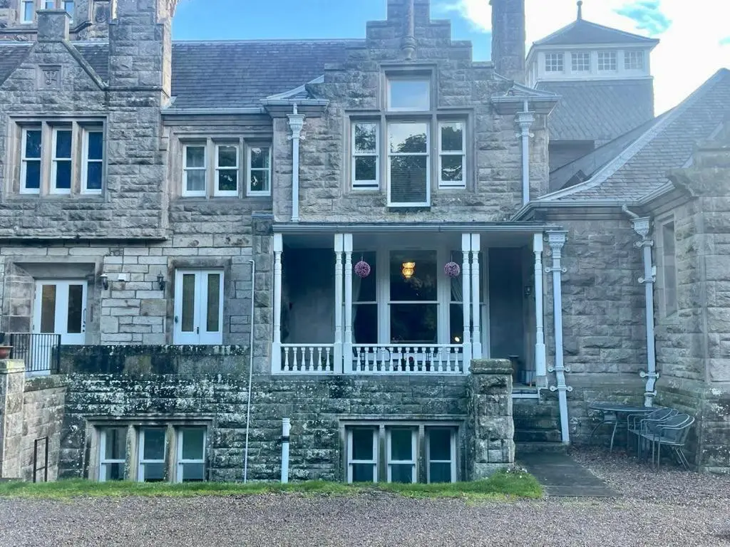 a stone house with a porch and a balcony at Serviced Accommodation Moray Lesmurdie House, Elgin - Free Parking, Free WiFi in Elgin