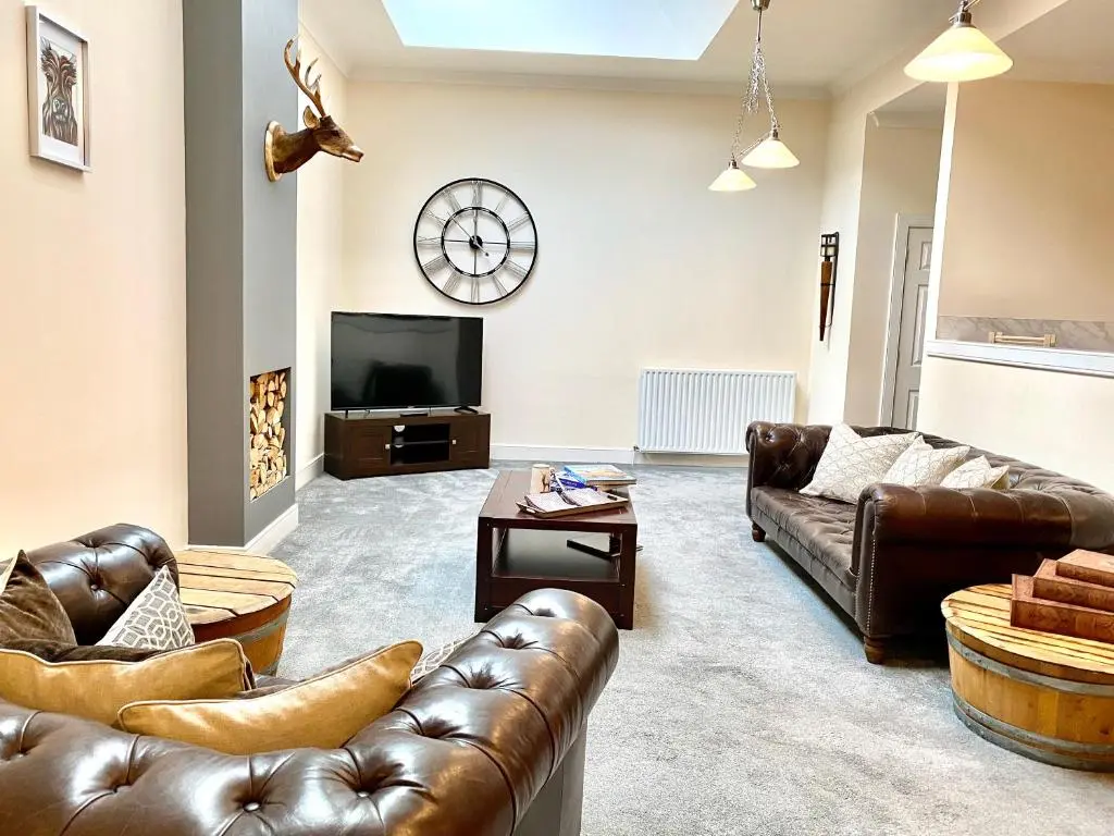 a living room with leather couches and a tv at Serviced Accommodation Moray Lesmurdie House, Elgin - Free Parking, Free WiFi in Elgin