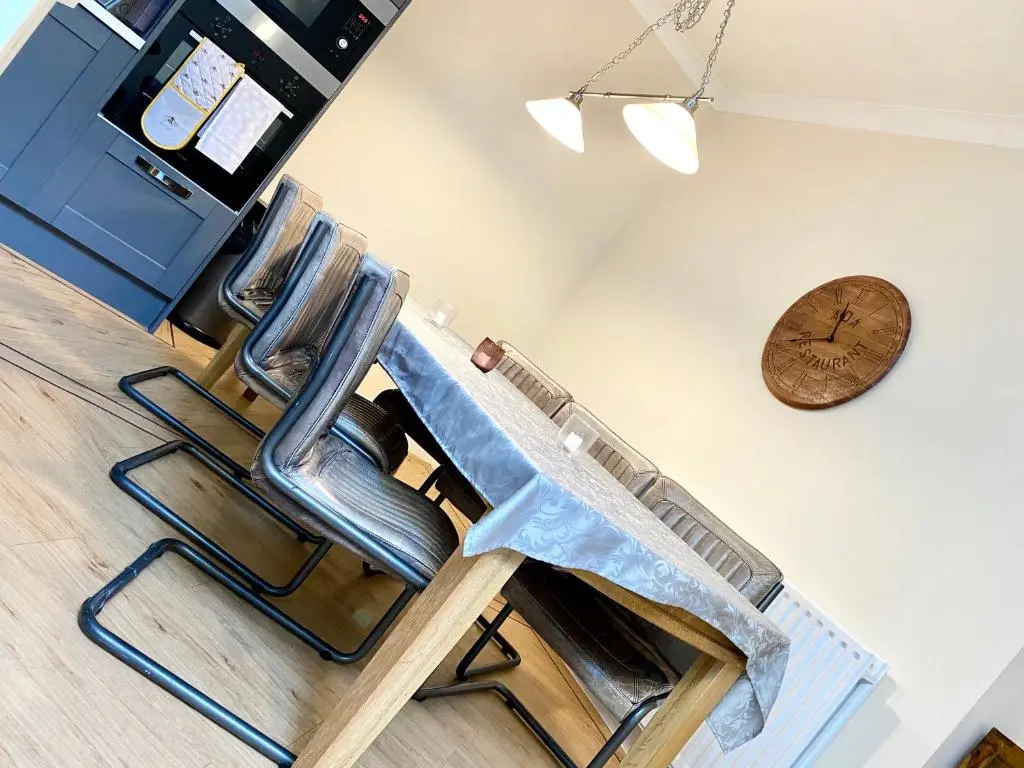 a barber chair in a room with a clock on the wall at Serviced Accommodation Moray Lesmurdie House, Elgin - Free Parking, Free WiFi in Elgin