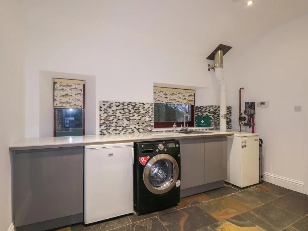 a kitchen with a washing machine in the middle at Orrinside in Muir of Ord