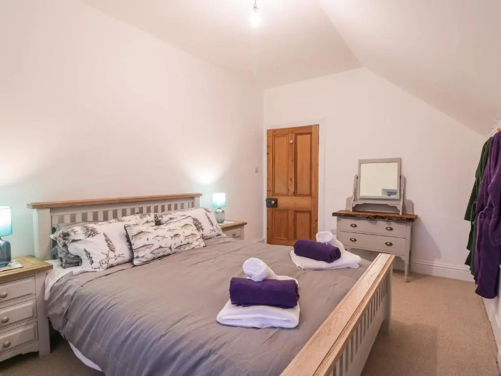 a bedroom with a large bed with towels on it at Orrinside in Muir of Ord