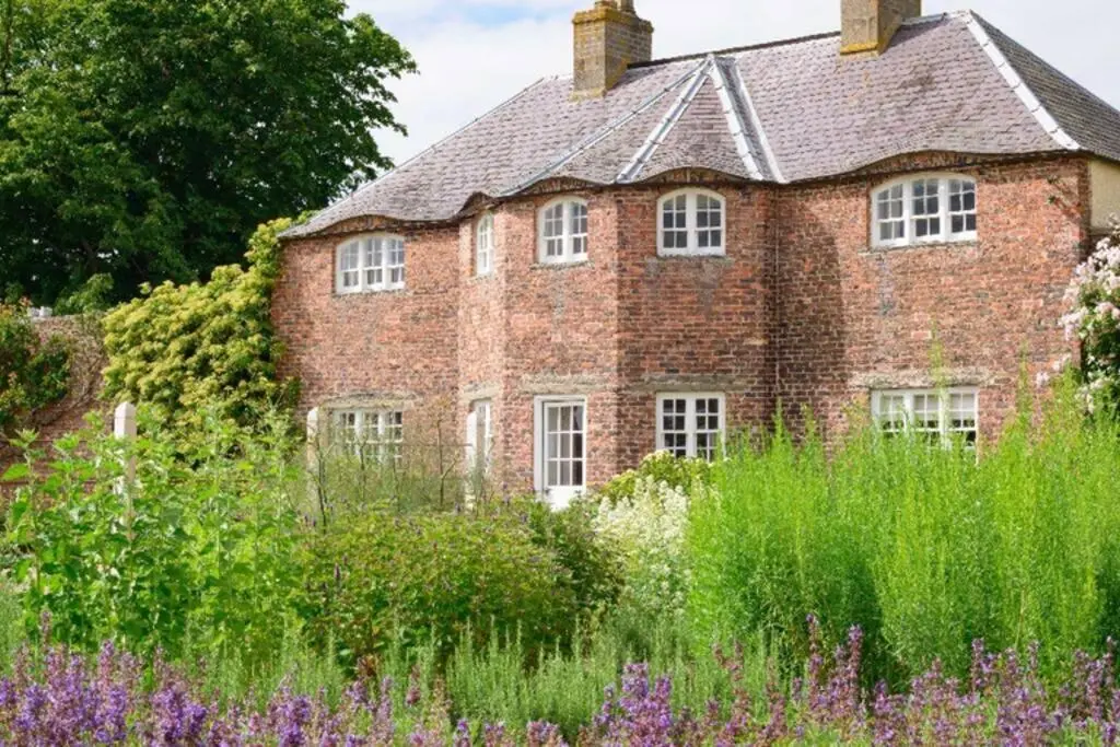 an old brick house with a garden in front of it at Garden Cottage, Fochabers in Fochabers