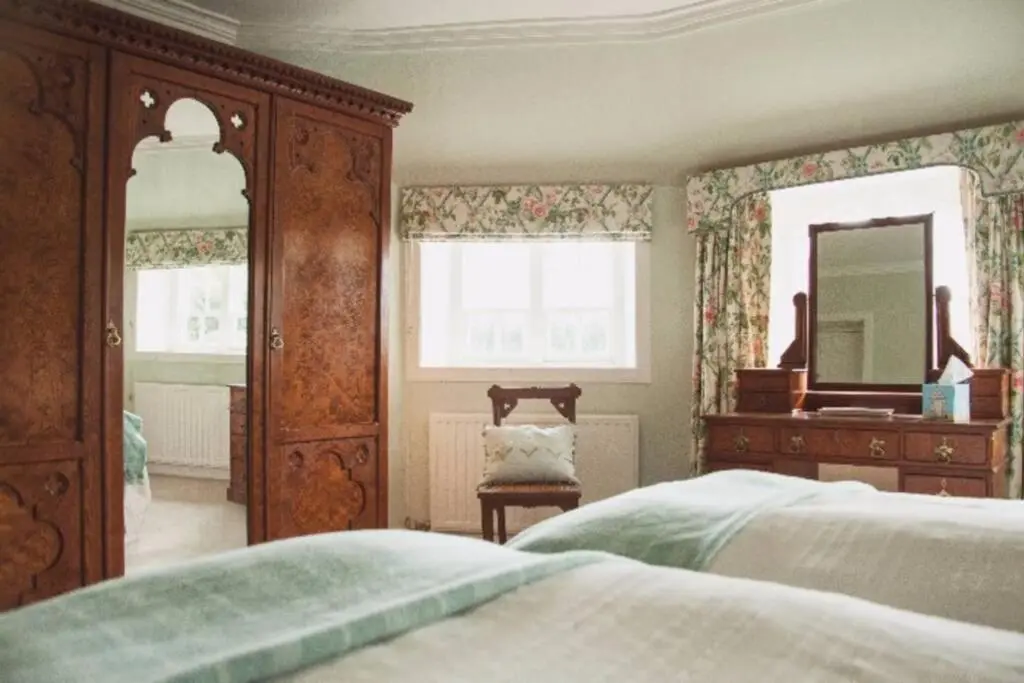 a bedroom with a bed and a dresser and a mirror at Garden Cottage, Fochabers in Fochabers