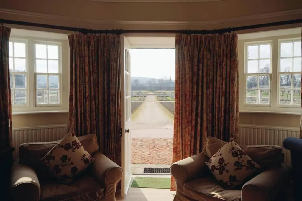 a living room with two chairs and a large window at Garden Cottage, Fochabers in Fochabers