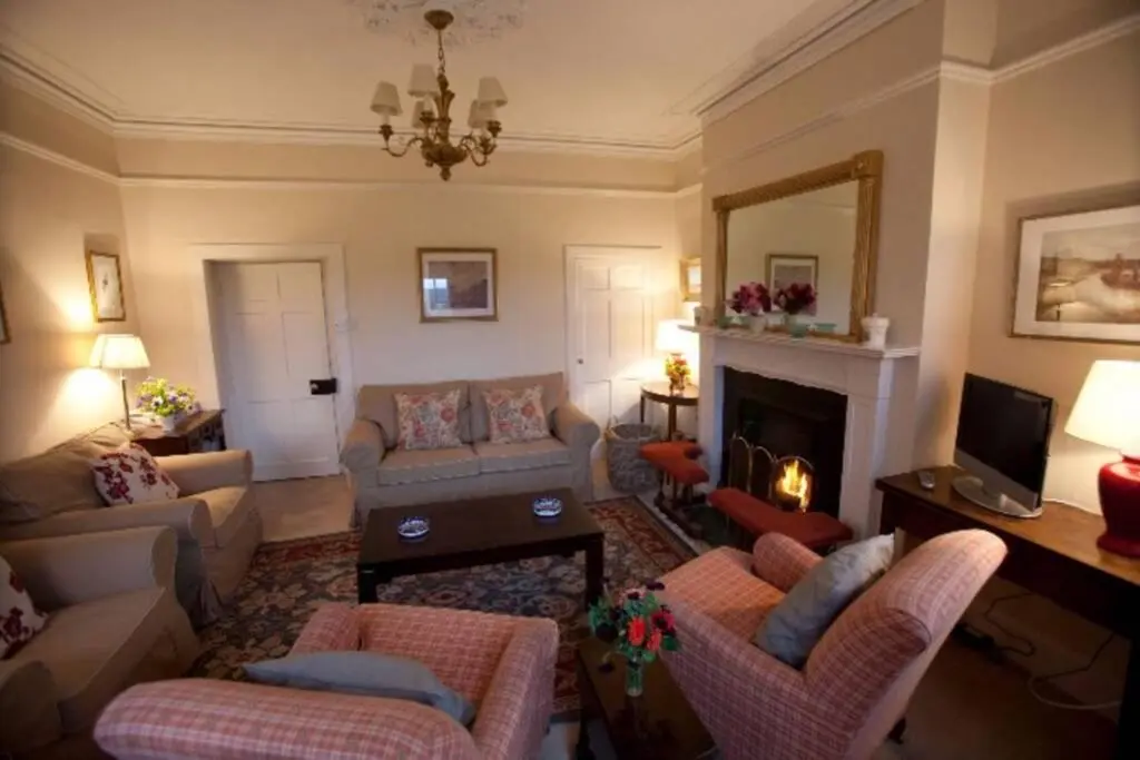 a living room with a couch and a fireplace at Garden Cottage, Fochabers in Fochabers