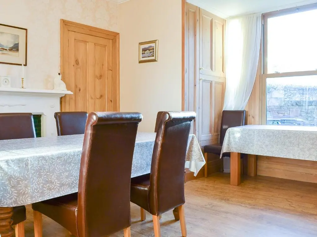 a dining room with a table and chairs at Brighton House in Nairn