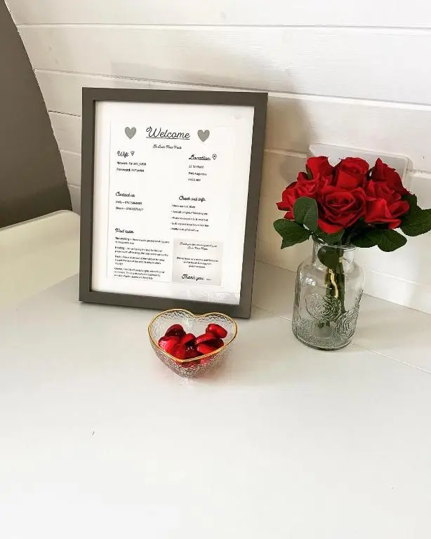 a table with a vase of roses and a picture at Loch Ness Pods in Fort Augustus