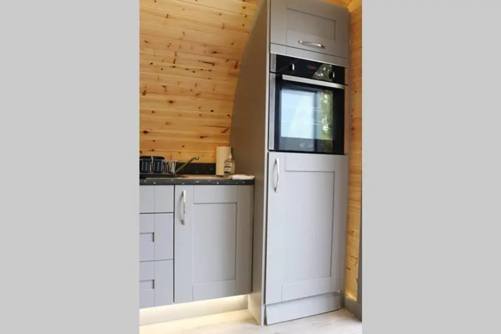a kitchen with white cabinets and a window at Glampods Glamping Pod - meet Highland Cows and Sheep Elgin in Elgin