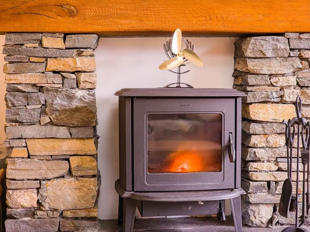 an old wood stove in a stone fireplace at Dalfern Lodge in Aviemore