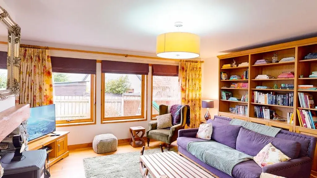 a living room with a purple couch and a tv at Dalfern Lodge in Aviemore