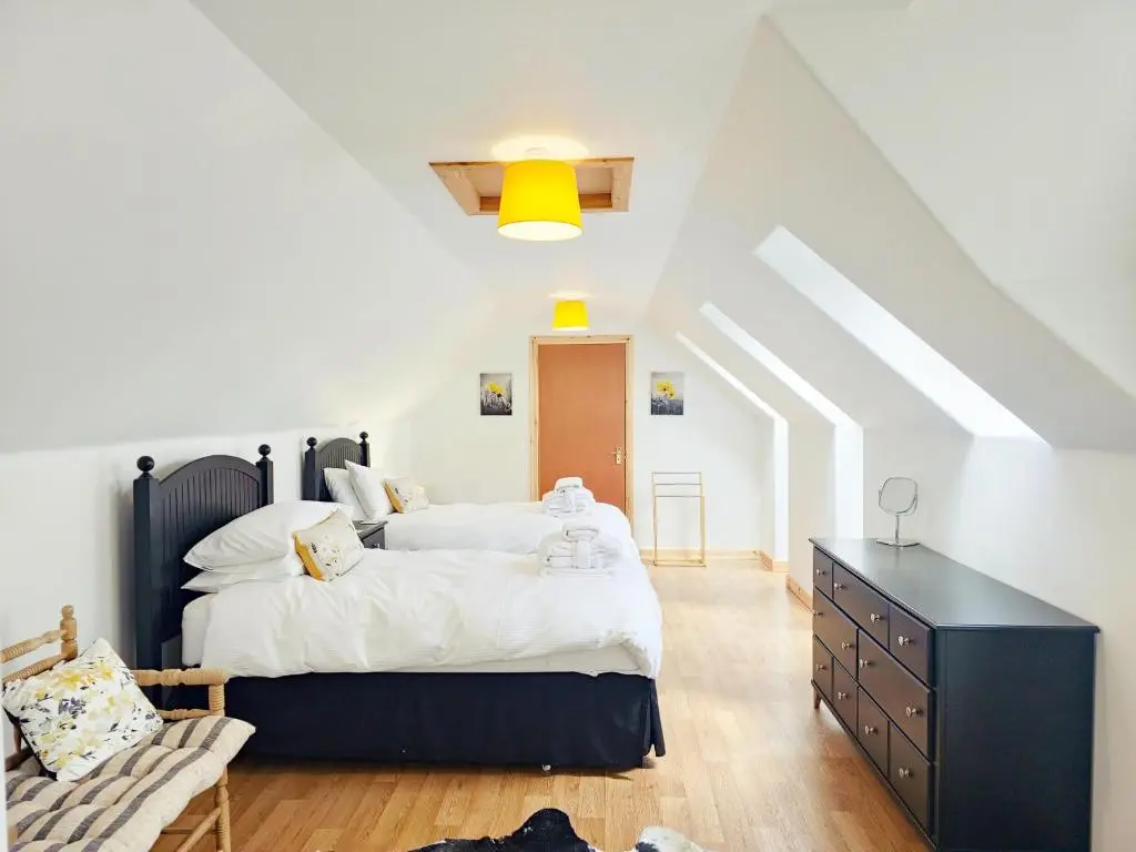 a bedroom with a large bed with a black dresser at Dalfern Lodge in Aviemore